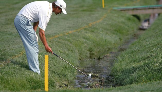Trước mặt là nước, phía sau là lựa chọn—cọc vàng biến một cú đánh thành bài toán giữa bản lĩnh và sự an toàn. (Nguồn ảnh: Trang tin Golf Edit)