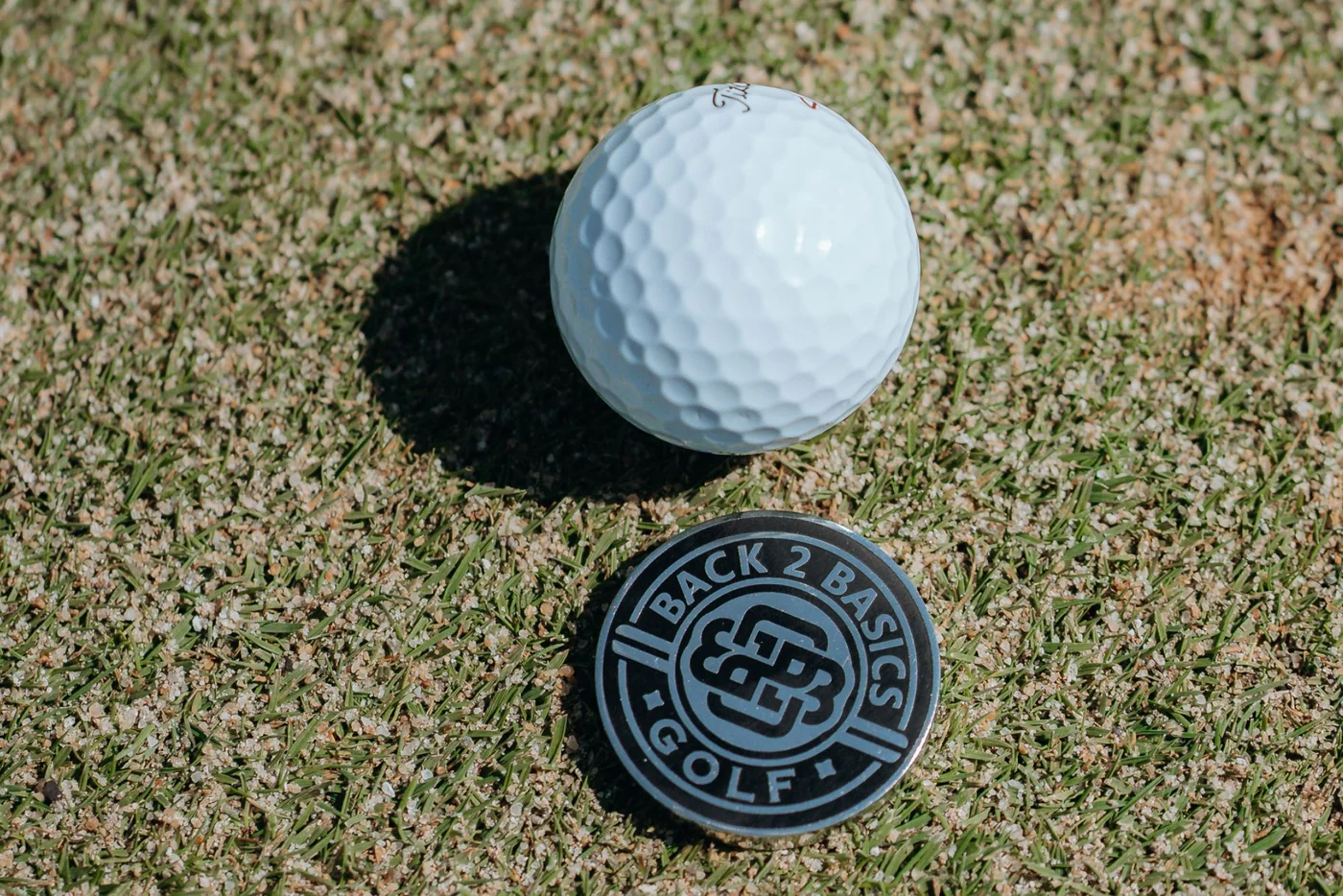 Ball marker giúp golfer đánh dấu vị trí bóng trên green, hỗ trợ nhấc bóng đúng quy trình và tránh nhầm vị trí khi putt. (Nguồn ảnh: Trang tin HS Golf)